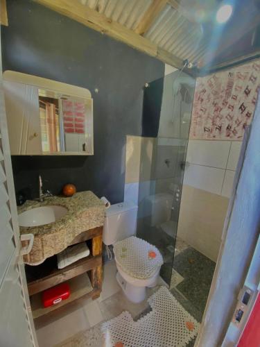 a bathroom with a toilet and a sink and a shower at Chalé cabana da mata in Bombinhas