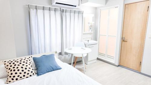 1 dormitorio con cama, mesa y lavamanos en 9stay蔵前, en Tokio