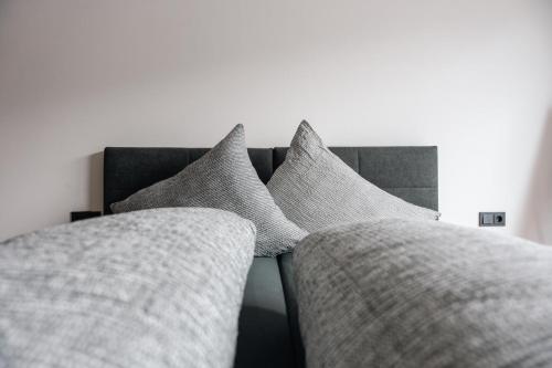 three pillows on a bed in a bedroom at Stadthaus Rosengartenschlucht in Imst
