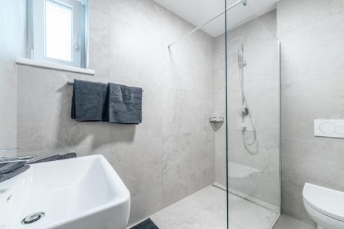 a white bathroom with a sink and a shower at Stadthaus Rosengartenschlucht in Imst