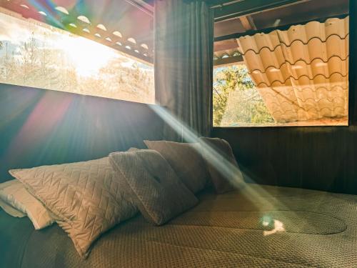 a bed with a pillow in a room with a window at EL TRAPICHE in Sigchos