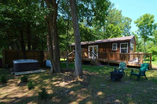 a cabin in the woods with two trees at Creekwalk Inn Bed and Breakfast with Cabins in Cosby