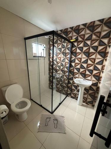 a bathroom with a shower and a toilet and a sink at Pousada Mãe Padroeira in Aparecida