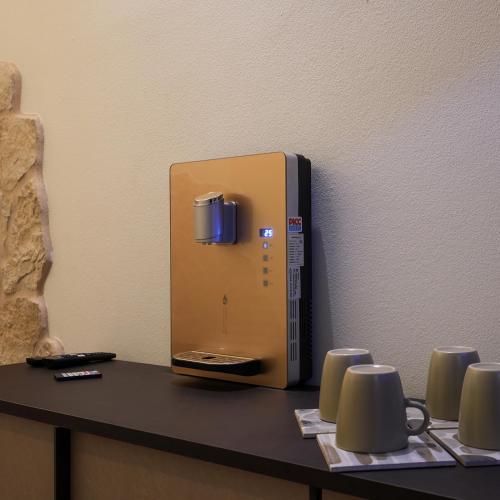 a coffee machine sitting on a table with mugs at Antica Corte Lugo in Lugo