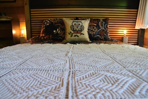 a large white bed with pillows on top of it at Cabane du hibou in Beauraing