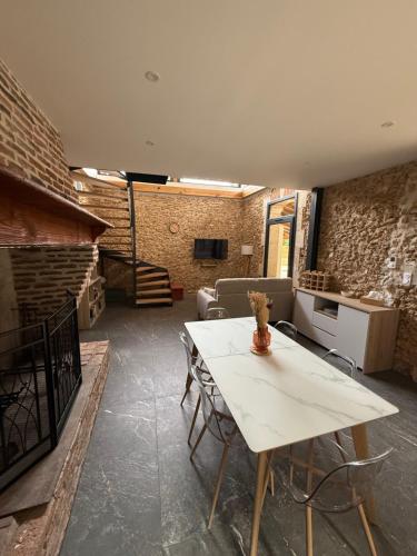 een woonkamer met een witte tafel en stoelen bij Gîte Domaine d'Hybère in Lucbardez-et-Bargues