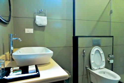a bathroom with a sink and a toilet at Villa Vaasa Luxury Homestay in Avathi