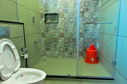 a shower with a glass door next to a toilet at Villa Vaasa Luxury Homestay in Avathi