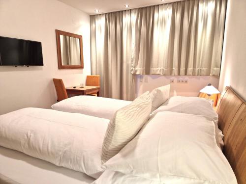 a hotel room with two beds and a television at Ferienwohnung Simonhof in Maria Alm am Steinernen Meer