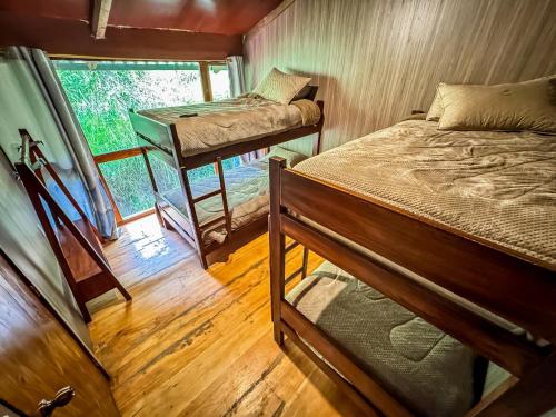 a bedroom with two bunk beds and a window at EL TRAPICHE in Sigchos