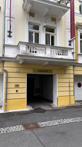 a building with a parking garage in front of it at Residence Romanza in Mariánské Lázně