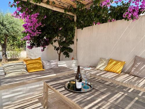 - un canapé blanc avec une bouteille de vin sur une table dans l'établissement Villa solea, piscine et Méditerranée, à Béziers