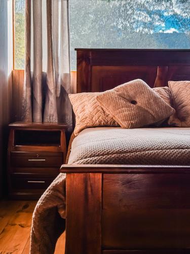 a bedroom with a bed and a window with curtains at EL TRAPICHE in Sigchos