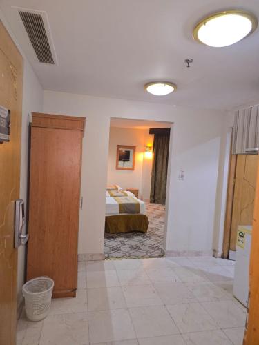 a bedroom with a bed and a door in a room at برج الجوار السكني أجياد المصافي Jiwar Tower Ajyad Al Masafi in Al Gharīth