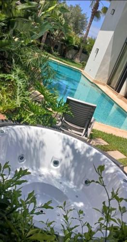 a bath tub sitting next to a swimming pool at Luxury Villa with Pool & Garden in Casablanca in Tamaris