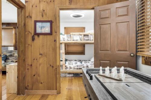 a room with a wooden door and a table at 2 Homes Retreat Game Rooms & Fire Pit Winni in Moultonborough