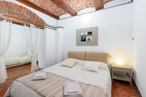 a bedroom with a bed in a room with white walls at Nel cuore di Bra - Intero alloggio con volte in Bra