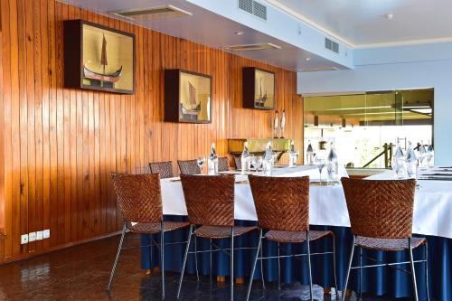 a dining room with a table with chairs and wooden walls at Pousada da Ria in Torreira