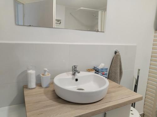 a bathroom with a white sink and a mirror at Dömper Döme Apartman in Balatonlelle