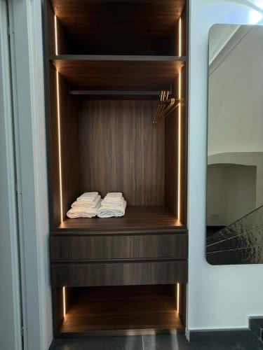 a closet with two folded towels on a wooden shelf at Carotenuto Palace in Boscotrecase