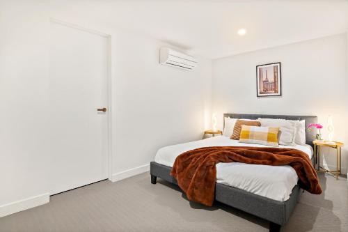 a white bedroom with a bed with a blanket on it at Luxury VIP 4-Bedroom Townhouse in Port Melbourne in Melbourne