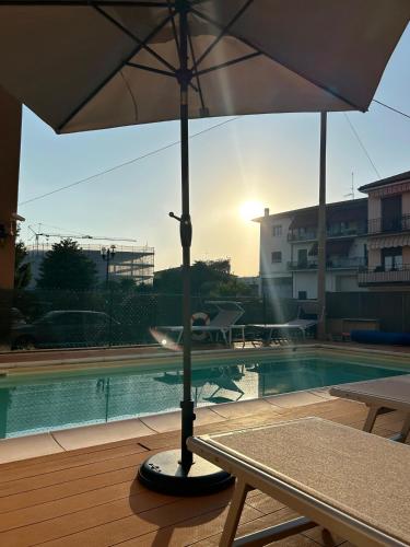 an umbrella sitting next to a swimming pool at Alessio Camere in Bardolino