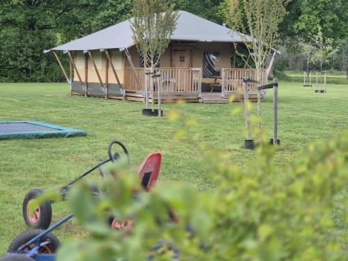 a building with a tent in a field at Klein Koestapel in Putten