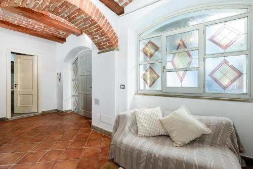 a living room with a couch and a window at Nel cuore di Bra - Intero alloggio con volte in Bra