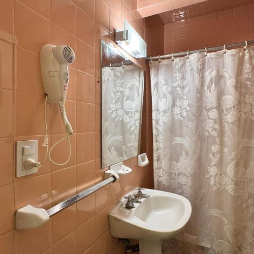 a bathroom with a sink and a shower curtain at Estocolmo Hotel by bund in Mar del Plata