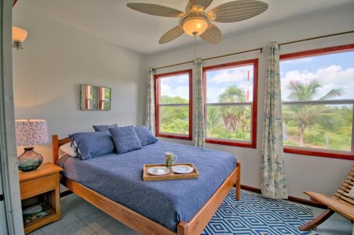 a bedroom with a bed and a large window at Escape Away Belize Beach House in San Pedro