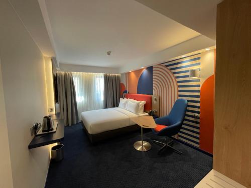 a hotel room with a bed and a desk and chair at Holiday Inn Express & Suites Lisbon - Príncipe Real by IHG in Lisbon
