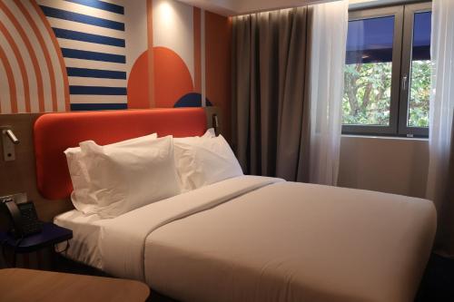 a hotel room with a bed and a window at Holiday Inn Express & Suites Lisbon - Príncipe Real by IHG in Lisbon