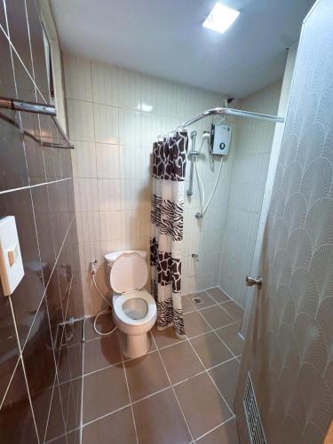 a bathroom with a toilet and a shower at Marianne Home Inn - PPC in Puerto Princesa City