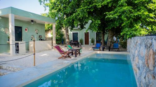 a swimming pool with chairs and a house at Charming colonial-style room in the heart of Valladolid in Valladolid