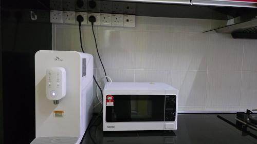 a microwave sitting on a table with a wii controller at Andalus Homestay in Jerantut