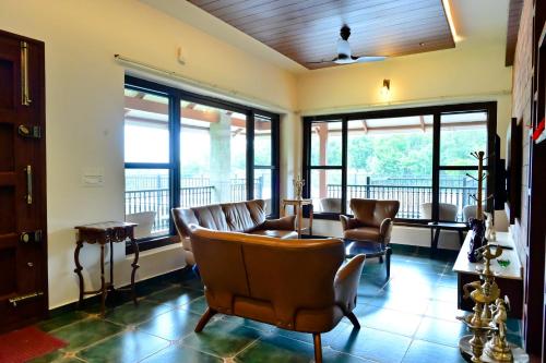 a waiting room with leather chairs and windows at Villa Vaasa Luxury Homestay in Avathi