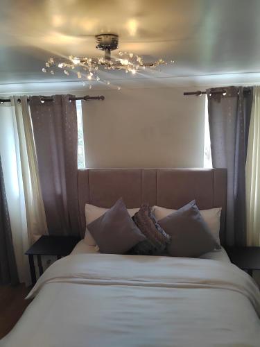 un lit avec des draps blancs et des oreillers dans une chambre dans l'établissement Stunning home next to Excel, London City Airport and East London University, à North Woolwich