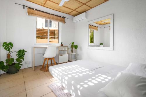 a white bedroom with a bed and a desk at Le Latanier - Perfect Mauritius Stay in La Gaulette