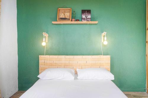 a bedroom with a green wall and a bed with two pillows at Le Latanier - Perfect Mauritius Stay in La Gaulette