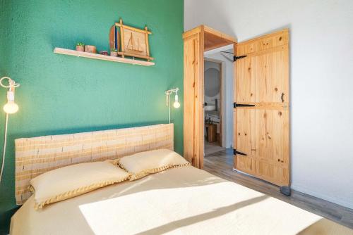 a bedroom with a bed and a green wall at Le Latanier - Perfect Mauritius Stay in La Gaulette