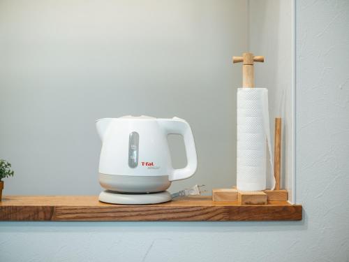 a white mixer on a wooden shelf with a roll of paper towels at Good Home Toyokawa in Hakodate