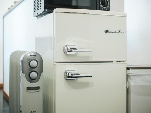 a refrigerator with a microwave on top of it at Good Home Toyokawa in Hakodate