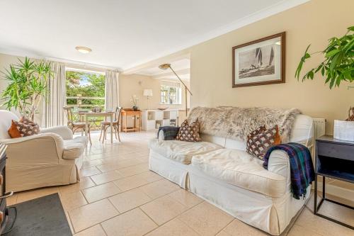 a living room with two white couches and a table at Mulberry Cottage in Nettlebed