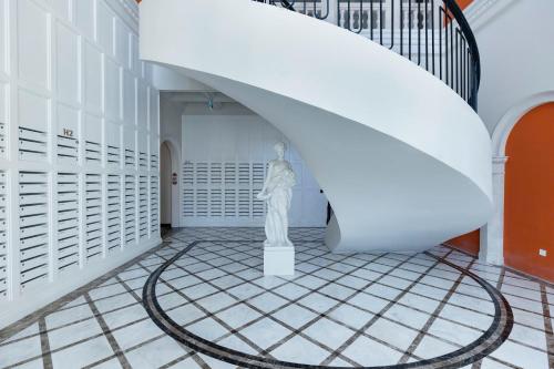a statue in a hallway with a spiral staircase at Capella Apartment Fireworks and Ocean View- Hillside Phu Quoc in Phu Quoc