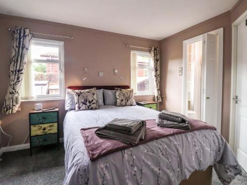 a bedroom with a large bed with two windows at 15 Badgers Retreat - Two Dales in Richmond