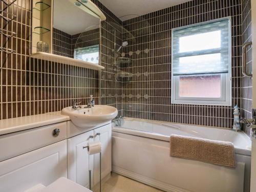a bathroom with a sink and a toilet and a tub and a sink at 15 Badgers Retreat - Two Dales in Richmond