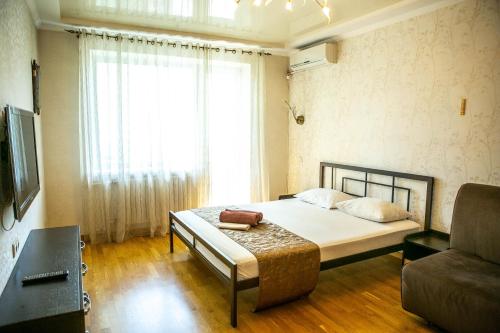 a bedroom with a bed and a large window at Doba In Ua Peremoga Apartments in Dnipro