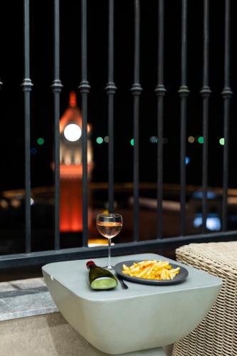 a table with a plate of food and a glass of wine at Capella Apartment Fireworks and Ocean View- Hillside Phu Quoc in Phu Quoc