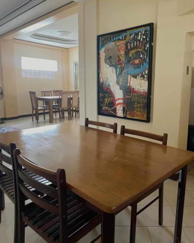a dining room with a large wooden table and chairs at Cozy 3br home entry to CWC, Pili Golf, Naga, Bicol in Pili