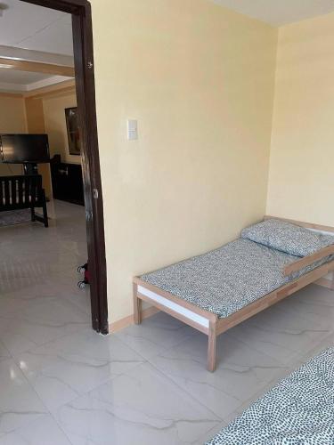 a bedroom with a bed in the corner of a room at Cozy 3br home entry to CWC, Pili Golf, Naga, Bicol in Pili